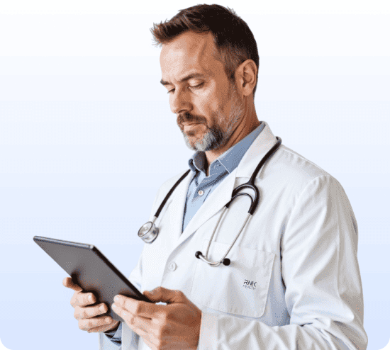 Doctor in a white coat with a stethoscope reviewing a tablet